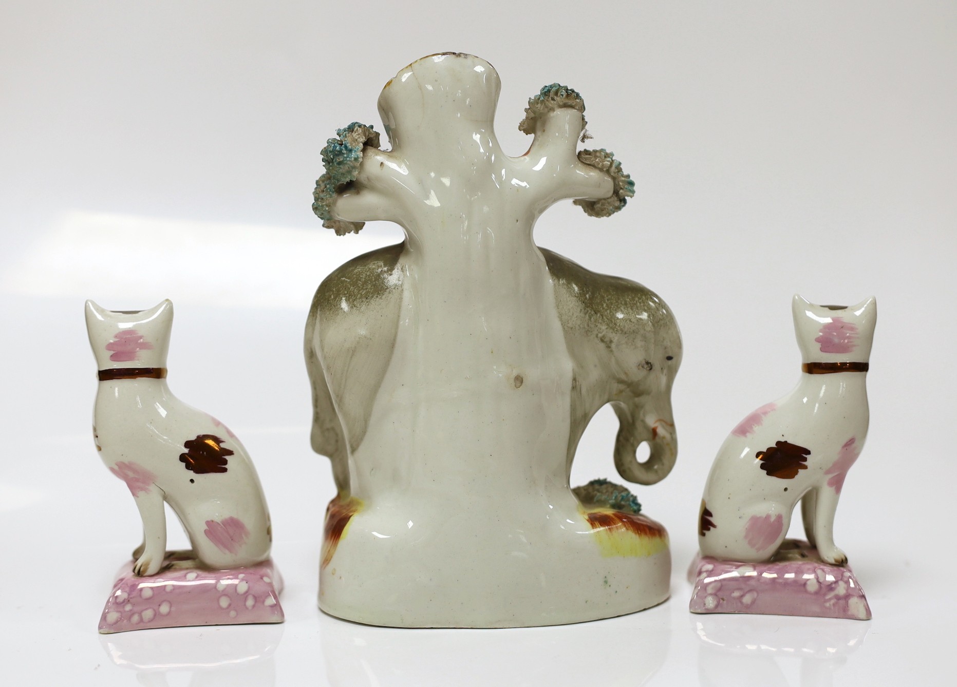 A Staffordshire elephant spill vase and a pair of cats, elephant 17cms high